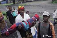 Funeral; A woman carries the body of a child who died of malnutrition.