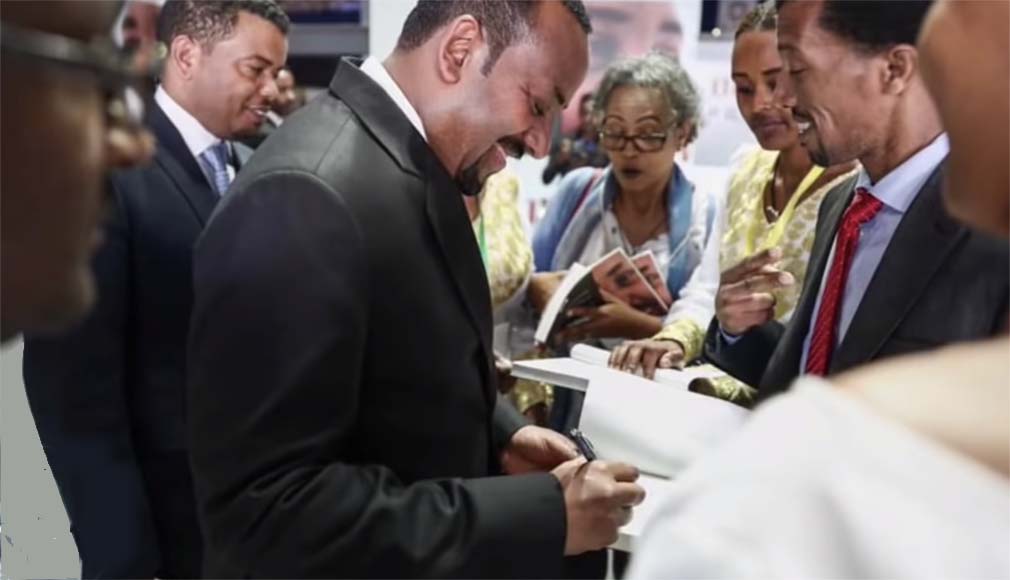 ጠ/ሚ ዶ/ር ዐቢይ አሕመድ የመደመር መጽሐፍ ምርቃት ላይ ፊርማ ሲያኖሩ