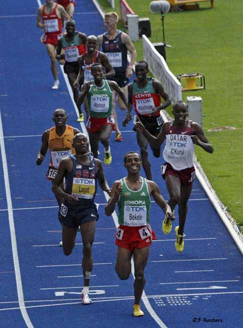Kenenisa Bekele of Ethiopia (C) celebrates as he crosses the finish line to win ahead of Bernard Lagat of the U.S. (L) and James Kwalia C'Kurui of Quatar (R) in the men's 5,000 metres final during the world athletics championships at the Olympic stadium in Berlin August 23, 2009.