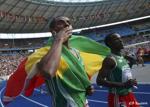 Kenenisa Bekele of Ethopia (L) and campatriot Ali Abdosh hold up their national flag as they celebrate after the men's 5000 metres at the world athletics championships at the Olympic stadium in Berlin August 23, 2009.