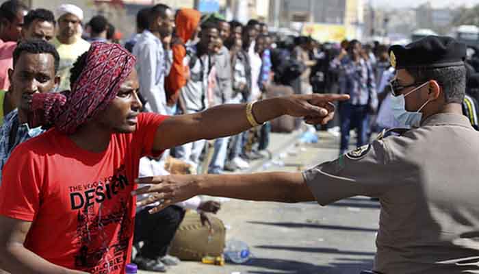 An Ethiopian worker argues with a member of the Saudi security forces.