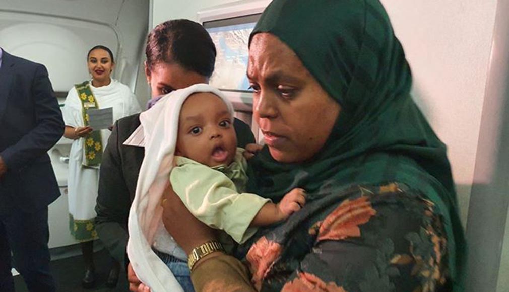 ጠ/ሚኒስትሩ ወደ ኢትዮጵያ ይዘዋቸው ከተመለሱት ጋር ውስጥ ልጇን ያቀፈች እናት