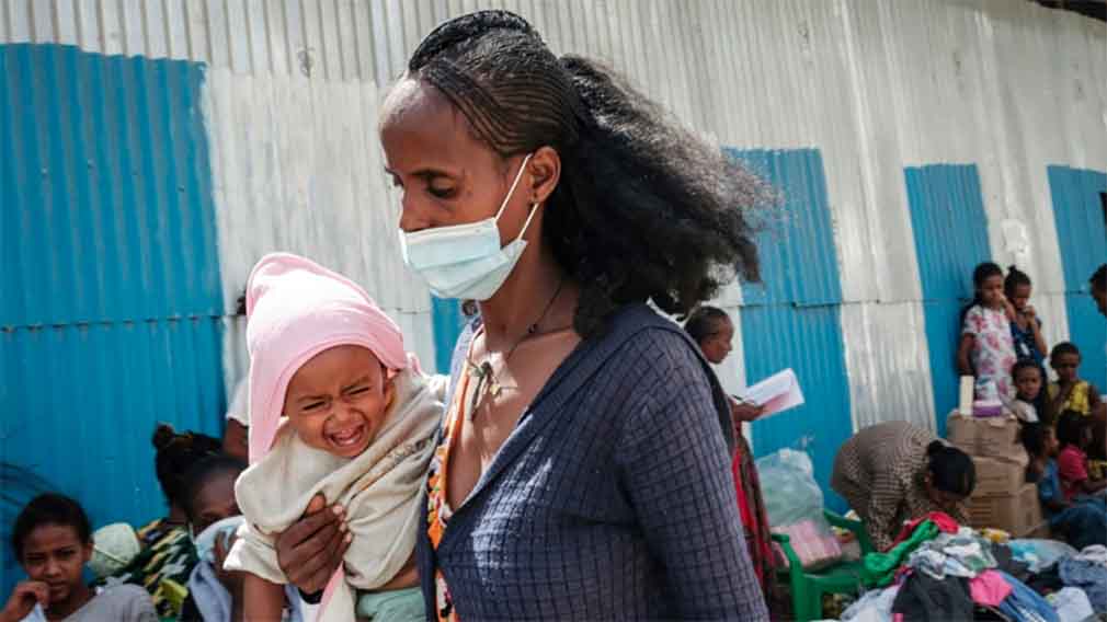 A mother in Mekele receives help from volunteers at a distribution centre on June 22